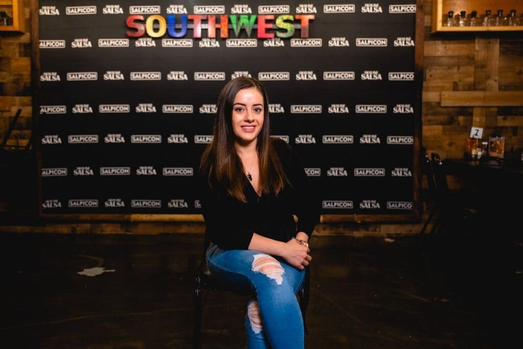 A woman smiles and sits for a photograph